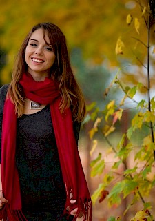 pretty girl Ariel Rebel plays with the autumn leaves